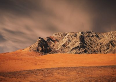 brown and white mountain under gray sky